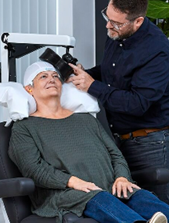 tmsband Patient receiving TMS therapy with the coil positioned by a clinician